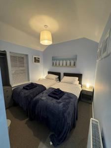 a bedroom with two beds with black towels on them at Jasmine Cottage, Newbiggin by the sea in Woodhorn