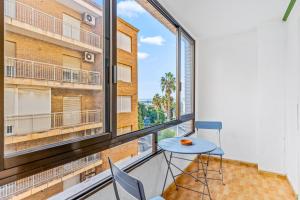 a room with a table and chairs and a large window at Unique Apartahotel 3-2 in Torrevieja