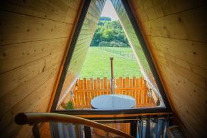 ein Bogenfenster in einer Hütte mit Blick auf einen Hof in der Unterkunft Domaine de la vôge & chalets et spa in Xertigny