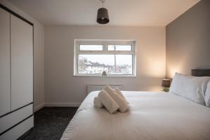 a bedroom with a white bed with a window at Rievaulx House in Stockton-on-Tees