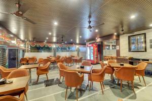 a dining room with wooden tables and chairs at Hotel Flysky Rooms & Banquets in Navi Mumbai