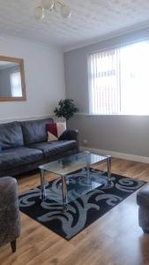 a living room with a couch and a glass coffee table at Spacious Victorian Double Room 3 in Balby