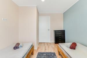 Habitación con 2 camas, paredes blancas y suelo de madera. en Juhkentali 46, korter 9, en Tallin