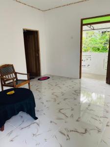 Cette chambre dispose d'un sol en marbre, d'une chaise et d'une porte. dans l'établissement Enjoy Villa Weligama, à Weligama