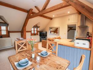 a kitchen and living room with a wooden table at Pultheley Cottage in Montgomery