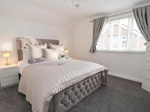 a bedroom with a large bed and a window at The Coastal Hideaway in Hornsea