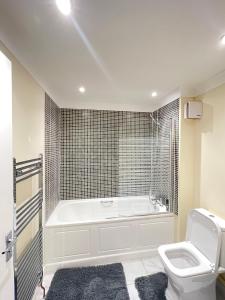a white bathroom with a tub and a toilet at Relaxing double rooms in a beautiful house in Ipswich