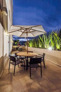 een tafel en stoelen met een parasol op een balkon bij Hotel Zenith in Tehuacán