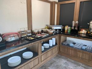 una cocina con encimera con platos blancos. en Fidanoğlu Suite Hotel Çorlu, en Çorlu