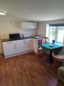 eine Küche mit einem Tisch und eine Küche mit einem Tisch und Stühlen in der Unterkunft Two Birds Weekly Stay in Malmesbury + 24 Fotos