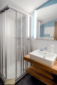 uma casa de banho com um lavatório e um chuveiro em Hotel Restaurant Alpina em Grindelwald