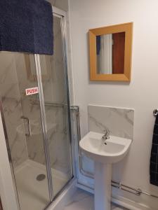 a bathroom with a shower and a sink at Two Birds Weekly Stay in Malmesbury