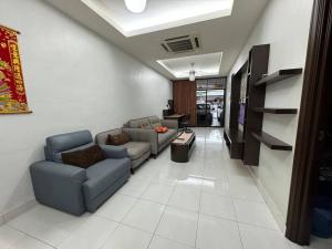 uma sala de estar com dois sofás e uma televisão em Cozy House 37 @ Alma BM em Bukit Mertajam