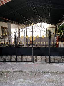 um portão preto com guarda-chuvas dourados em Cloudnine Home Thrissur em Thrissur