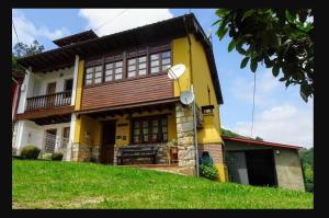 ein großes gelbes Haus auf einem grünen Hügel in der Unterkunft Casa Albina in Ríofabar
