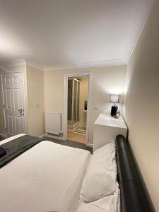 um quarto com uma cama branca e uma mesa branca em Relaxing double rooms in a beautiful house em Ipswich