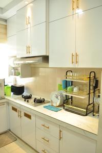 a kitchen with white cabinets and a counter top at De’ Nuhir Homestay Teluk Senangin 