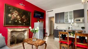 uma cozinha e uma sala de estar com uma parede vermelha em Residence Flowery em Veneza