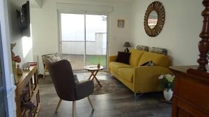 een woonkamer met een gele bank en een tafel bij Des vacances à 4 à Talmont St Hilaire in Talmont