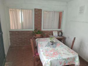 jadalnia ze stołem, krzesłami i oknami w obiekcie Flia Martínez alojamiento w mieście San Fernando del Valle de Catamarca