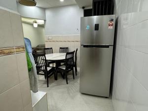 Il comprend une cuisine équipée d'un réfrigérateur et d'une table avec des chaises. dans l'établissement Cozy House 37 @ Alma BM, à Bukit Mertajam