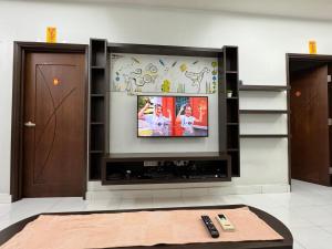 ブキッ・ムルタジャムにあるCozy House 37 @ Alma BMの壁に薄型テレビが取り付けられたリビングルーム