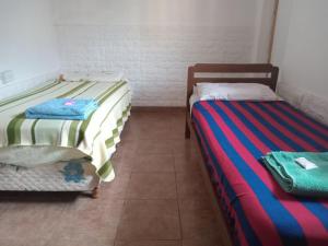 dwa łóżka siedzące obok siebie w pokoju w obiekcie Flia Martínez alojamiento w mieście San Fernando del Valle de Catamarca