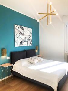 a bedroom with a large bed with a blue wall at Elegante e spazioso appartamento in Milan
