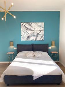 a bedroom with a large bed with a blue wall at Elegante e spazioso appartamento in Milan