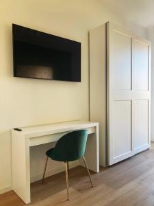a desk with a chair and a television on a wall at Elegante e spazioso appartamento in Milan