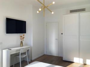 a white room with a desk and a tv on the wall at Elegante e spazioso appartamento in Milan