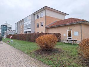 un bâtiment avec un banc devant lui dans l'établissement Apartment Hundige, à Greve