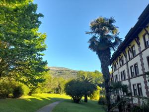 a palm tree in front of a building at Balneario Casa Pallotti in Carranza