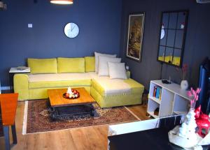- un salon avec un canapé jaune et une table dans l'établissement Mila Apartment, à Skopje