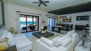 un soggiorno con mobili bianchi e l'oceano di Casa Javi- Ocean Front located Mid Isla Mujeres a Isla Mujeres