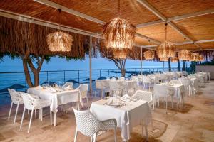 a restaurant with white tables and chairs and chandeliers at Yalihan Aspendos in Alanya