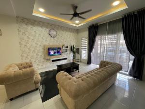 sala de estar con 2 sofás y TV en De’ Nuhir Homestay Teluk Senangin, 