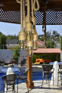 einen Kronleuchter, der von einer Terrasse mit Stühlen und Tischen hängt in der Unterkunft Halibut Hotel in La Romana