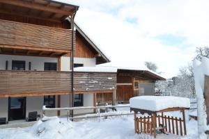 een huis in de sneeuw met sneeuw op de veranda bij Biohof Auinger, der Tiererlebnishof in Aurach am Hongar
