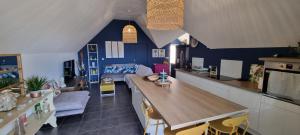 cocina con paredes azules y mesa en una habitación en Appartement Corail, situé à 2 min du lagon, en Saint-Leu