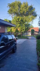 een auto geparkeerd op een oprit naast een boom bij Charly's House in Mar del Plata