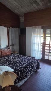 1 dormitorio con 1 cama con manta blanca y negra en Charly's House en Mar del Plata