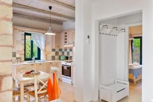 a kitchen and dining room with a table and chairs at Villa Melpomene St George Retreat BY APOKORONAS-VILLAS in Kókkinon Khoríon