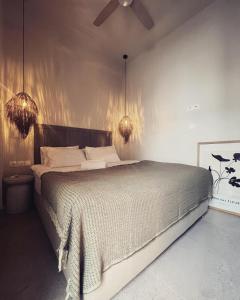a bedroom with a large bed with a ceiling fan at Luxurious wooden detail flat in city center in Chalkida +31 photos