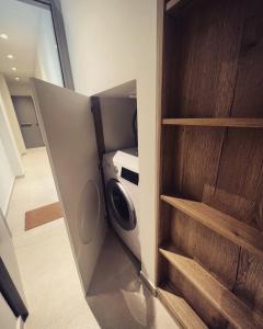 a small laundry room with a washer and dryer at Luxurious wooden detail flat in city center in Chalkida