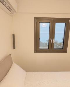 a bedroom with a window and a bed in it at Sea…you soon in Poros