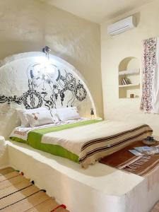 El MâyにあるDar Oueghlani - Maison d'hôtesのベッドルーム1室(白黒のヘッドボード付きのベッド1台付)