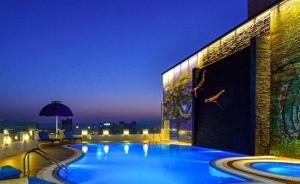 a swimming pool on top of a building at night at Swiss-Belhotel Seef Bahrain in Manama