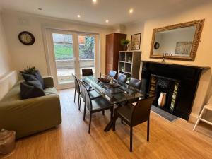 a living room with a dining table and a fireplace at 4 bed house 10 min walk to Tube in London