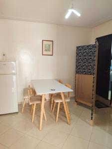 a kitchen with a table and chairs and a refrigerator at Appartement propre et bien équipé à Ain sebaa in Casablanca